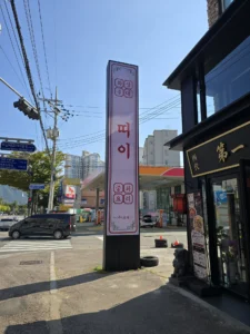 띠이와 중화요리 글자가 적힌 세로 간판과 검은색 매장 외관